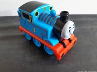 Left front view of blue Thomas engine showing number 1 and six wheels