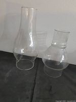 Both clear glass hurricane shades side by side