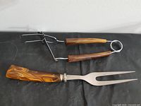 Both utensils laid out: carving fork and barbecue tongs
