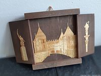 Front view open showing complete marquetry scene and folding panels