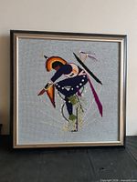 Full view of framed needlepoint artwork