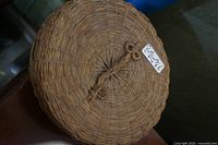 Top view showing woven pattern, lid, braided latch and size tag