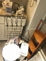 Corner shelf, waste bin, black wire stand, storage baskets visible