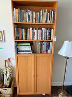 Front view of entire bookcase showing shelves filled with books and lower cabinet doors