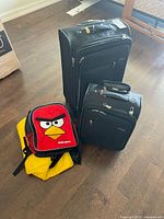 Overview of two suitcases, Angry Birds backpack, yellow tote
