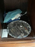 Tray with assorted silver-plated cutlery on shelf