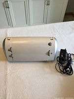 Closed Cricut CRV001 cutter with power adapter