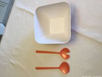 Top view of white-interior square bowl and two orange servers