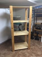 Front angled view of one pine shelving unit showing four slat shelves