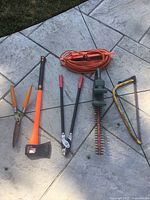Full set of garden cutting tools and extension cord displayed on patio