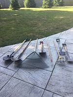 All seven garden tools laid out on patio