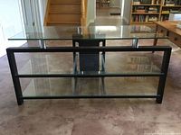 front view showing three glass shelves, black metal frame