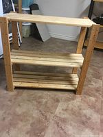 Frontal view of full shelving unit showing three shelves and pine construction