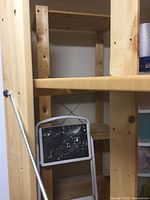 Close view from behind through frame, showing shelf construction and hardware