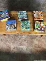 Six puzzle boxes on bench: Saks Fifth Avenue, France, 3-D globe, Notre Dame Cathedral, France map, World’s Most Difficult