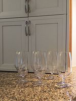 Six clear plastic beer glasses on countertop