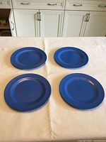all four blue plastic plates on table