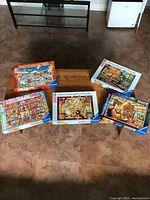 All five boxed Ravensburger puzzles displayed