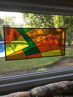 Full view of stained glass panel hanging in window
