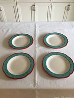Four dinner plates displayed on table