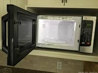 Microwave oven open showing interior and glass turntable