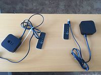 Both Apple TV units with their remotes and power cords displayed on tabletop