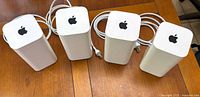 Front view of four Apple AirPort Extreme routers standing side by side