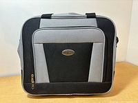 Front view showing gray and black color, zip pocket and logo