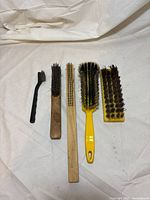 Five tools laid out showing size comparison and bristle types