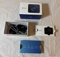 All kit components laid out with packaging, dash cam, cables, mount