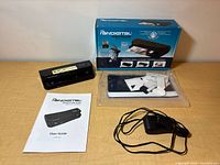 Full lot view: scanner, retail box, user guide, sealed calibration sheets, power adapter
