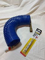 Coiled blue air hose and packaged blow gun