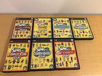 Front view of seven Sims 2 Stuff Pack cases