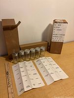 Six glass spice jars with metal lids, cardboard boxes, label sheets and ruler for scale