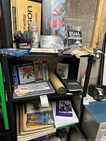 Shelf with Arteza pencil set, Tombow brush pens, large yellow sketch pad, mug with tools and various supplies