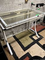 full view of glass top desk showing frame, legs and glass surface