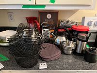 Overall view of lot on countertop including kettle, pitcher, grater, bowls, baskets and more