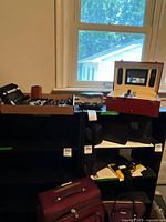 Overall view of lot on shelf showing trays with sunglasses, knives, watch box