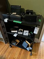 Full front view of black rolling shelf with contents visible but not included