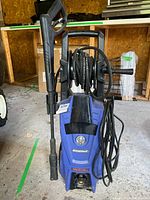 Front view of Simoniz S1900 pressure washer with hose reel, spray wand and power cord visible