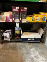 Shelf with industrial drum liners, Glad trash bags, Hefty kitchen trash bags, Philips LED bulb boxes, Scott Pro towel roll