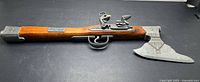 Left side view of decorative flintlock pistol with axe head