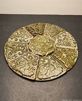 Front view of full nine-segment carved stone disc