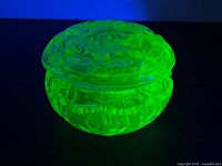 Lidded uranium glass dish glowing under UV light