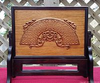 Front view showing carved fan motif and stand