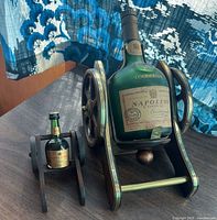 Large and miniature Courvoisier bottles on stands front view