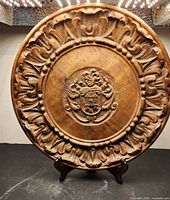 Front view of carved wooden plate on stand