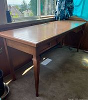 Full view of wooden desk with two drawers and outlets on top