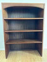 Front view showing four fixed shelves and arched top