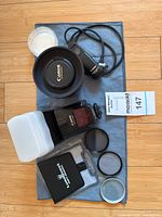 Top view of all items laid out including lens, flash, filters, remote, charger, cloth